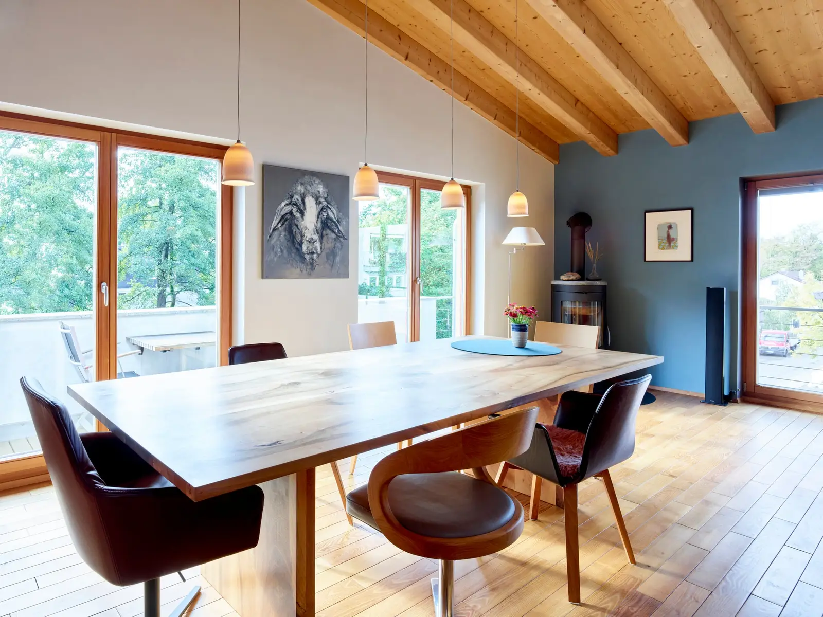 Essbereich mit blauer Lehmwand und großem Holztisch