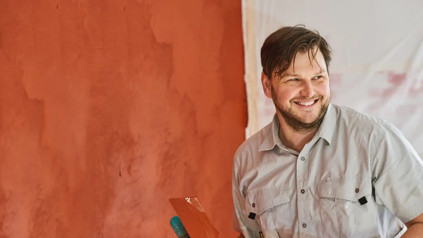 Martin Bräuninger vor einer Wand mit rotem Kalkputz